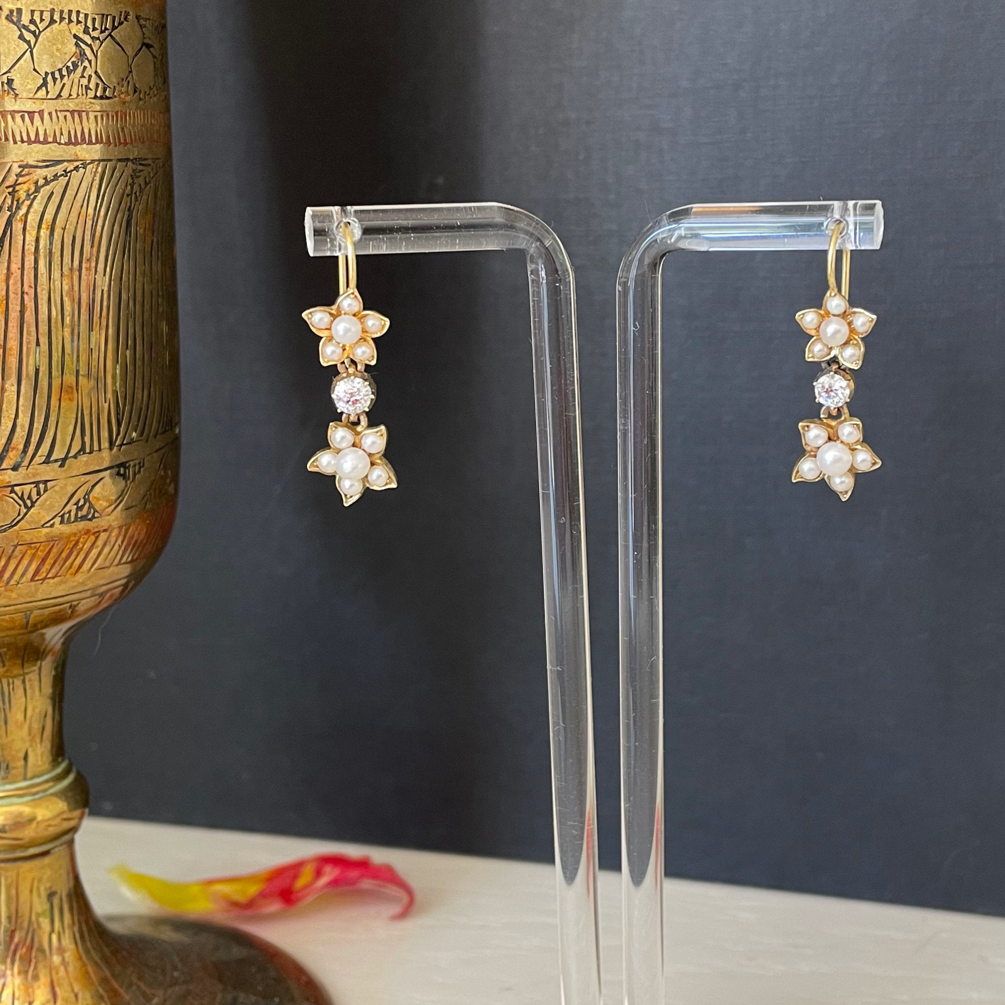 Gold earrings with pearl flowers and diamond drops.