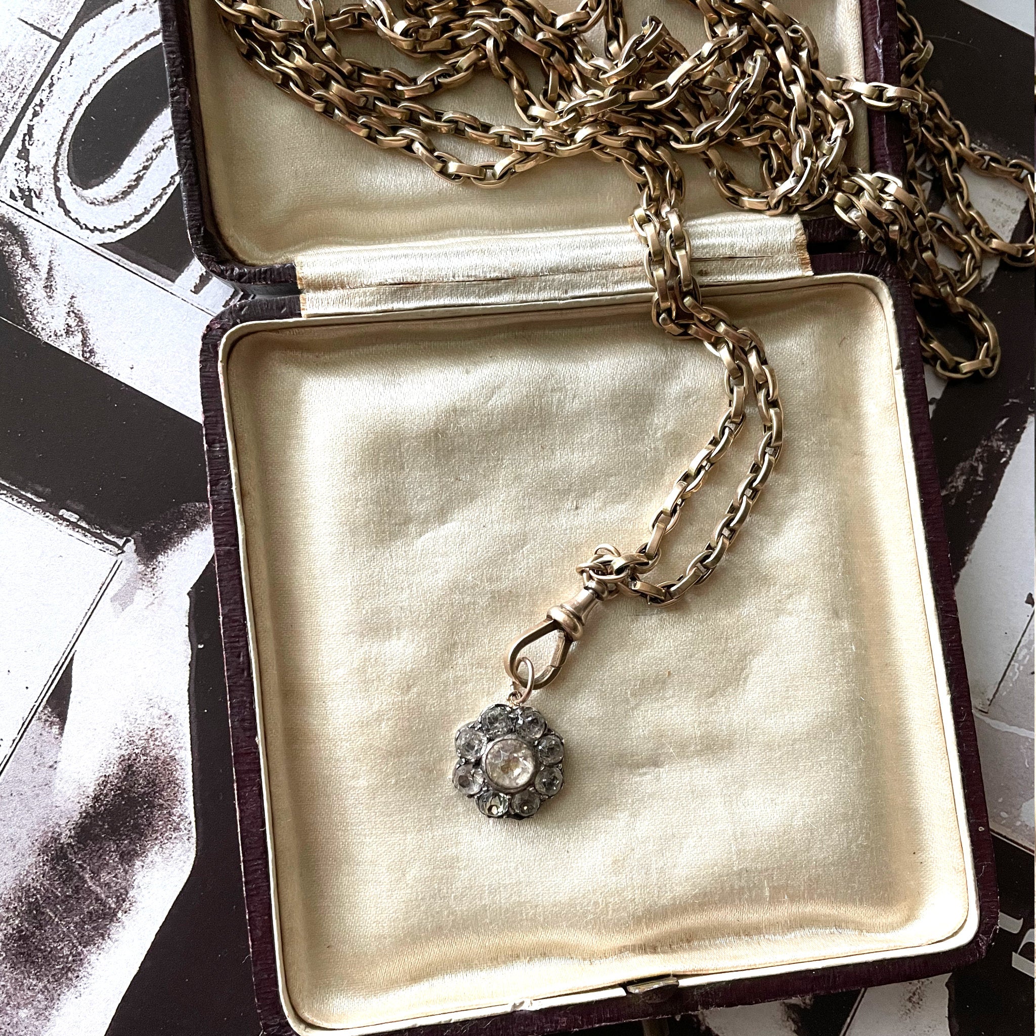 Pretty flower pendant made of antique white paste and silver on a long guard gold chain in a jewellery box with white silk.