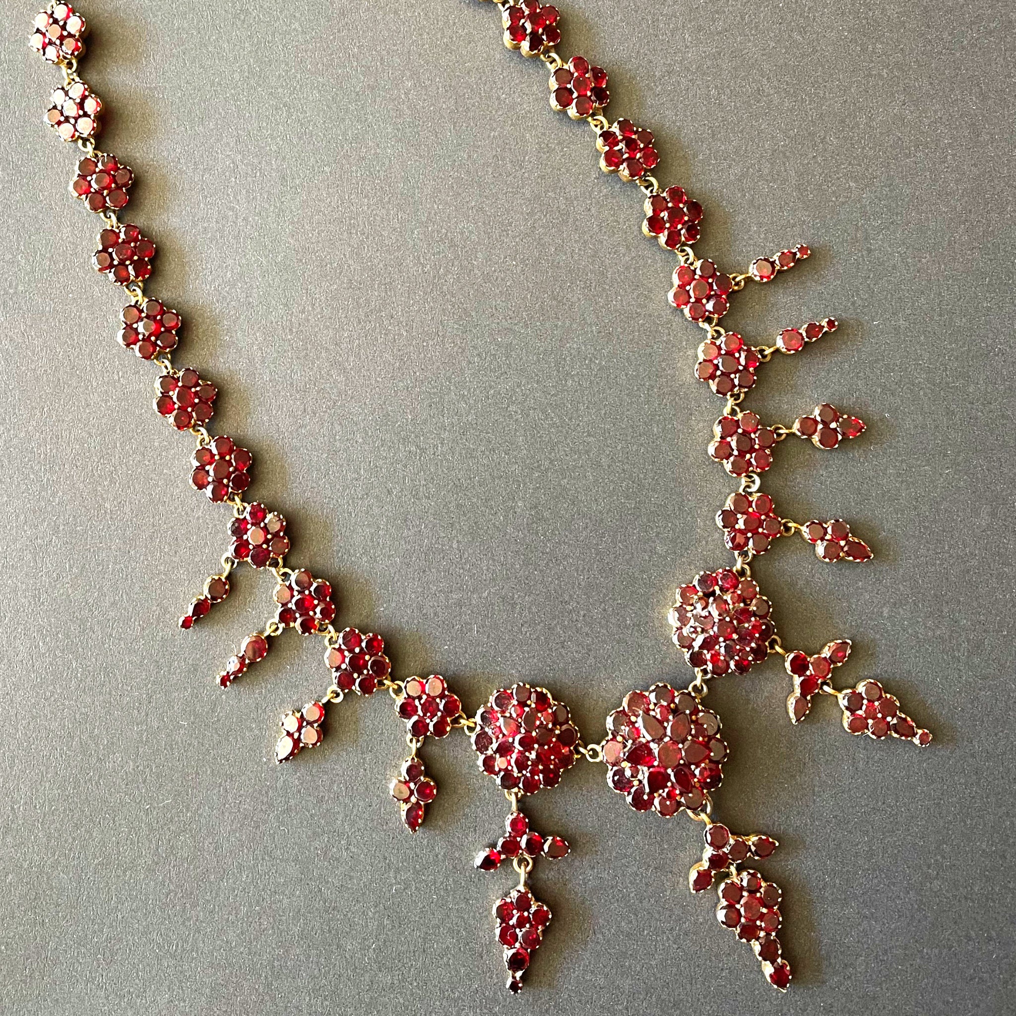 garnet drop necklace on black background