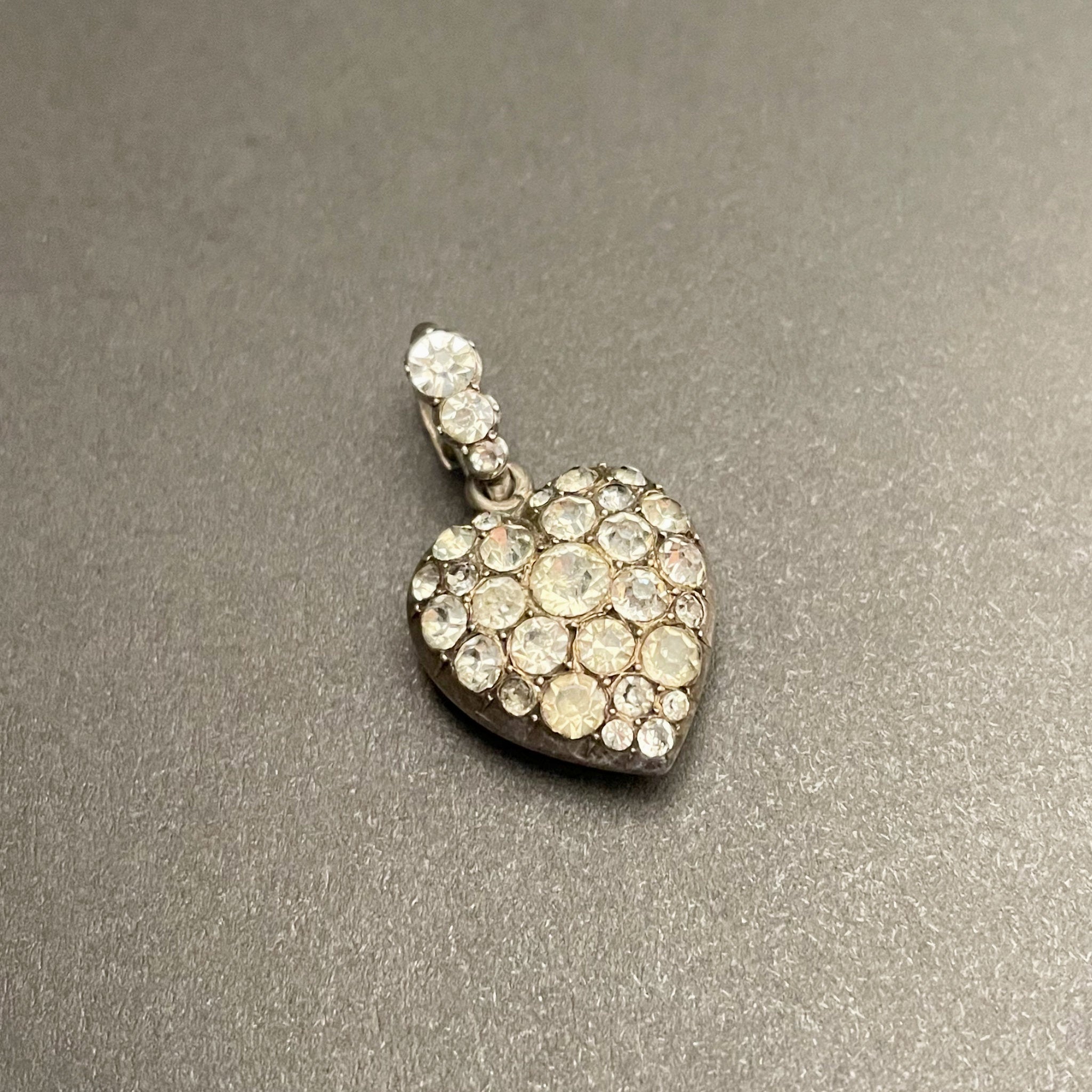Antique silver heart shaped pendant with colourless paste stones all over.