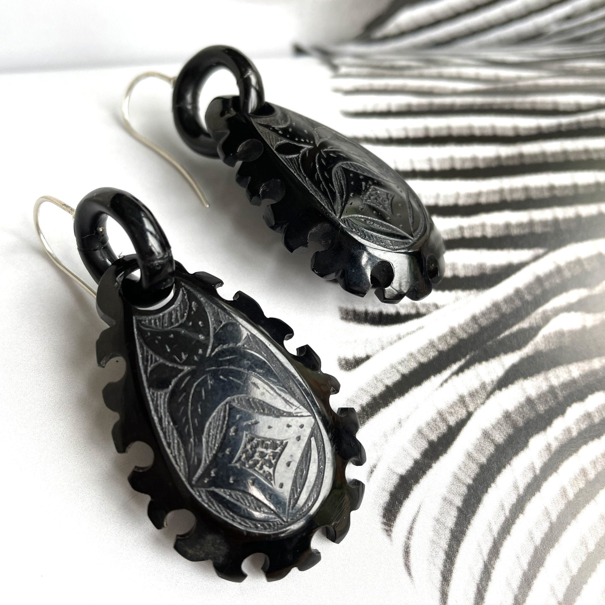 Antique drop earrings each with two flowers made of seed pearls separated by a bright diamond.