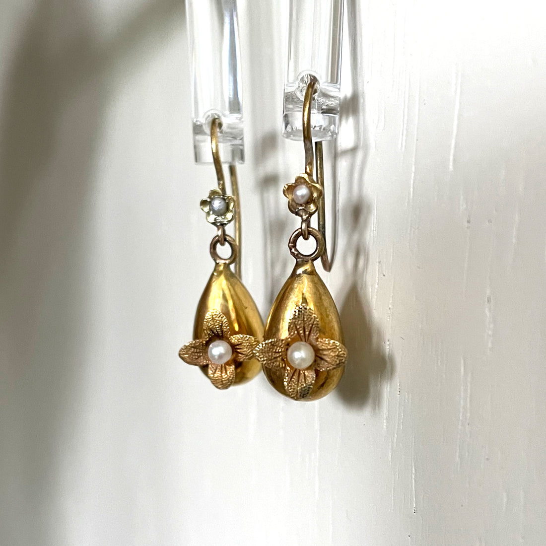 Gold drop earrings with flowers and pearls.