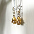 Gold drop earrings with flowers and pearls.