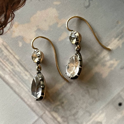 Antique white paste earrings on wallpaper background.