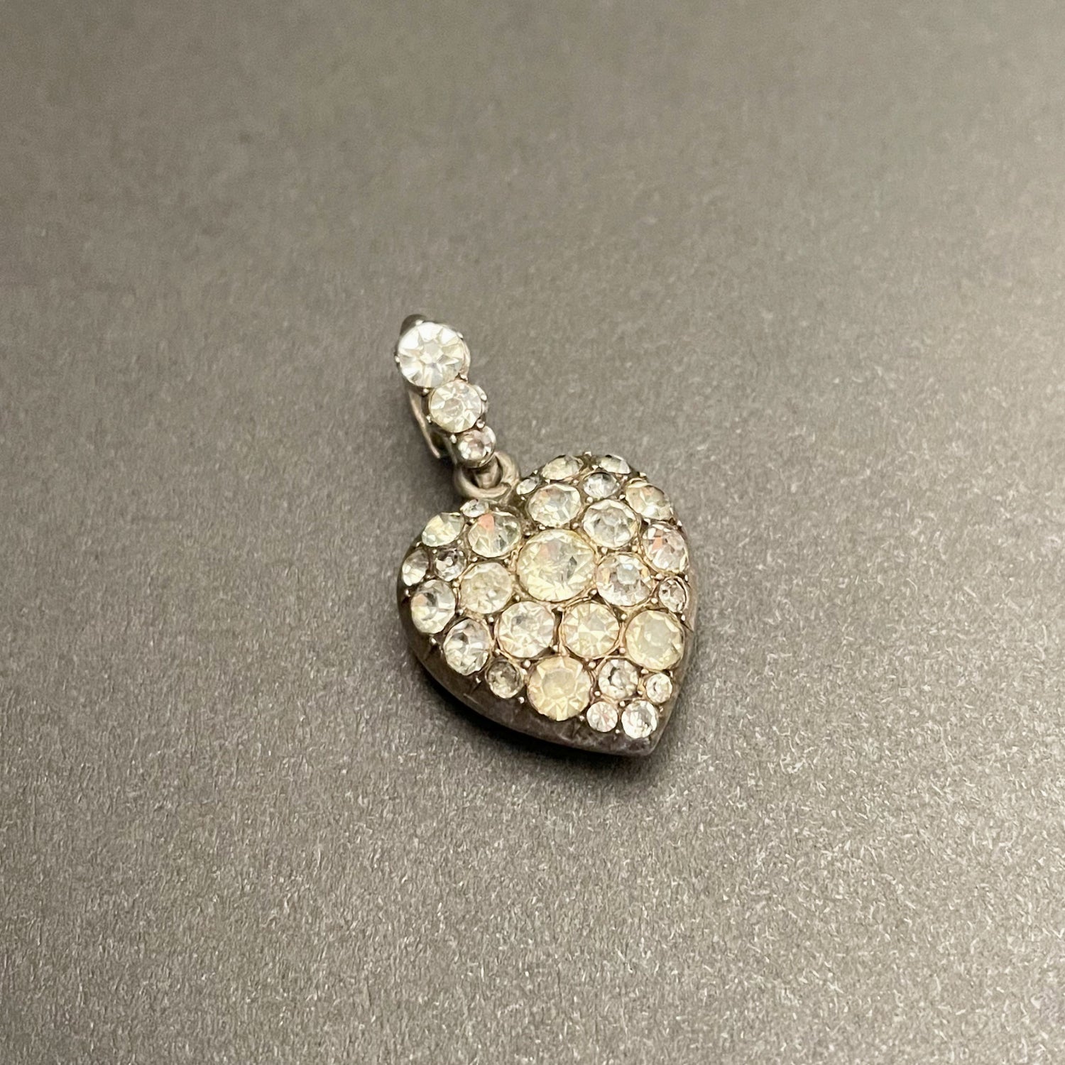 Antique silver heart shaped pendant with colourless paste stones all over.