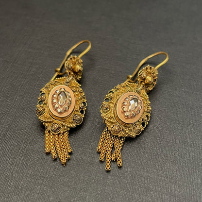 Intricately detailed gold earrings with tassels.