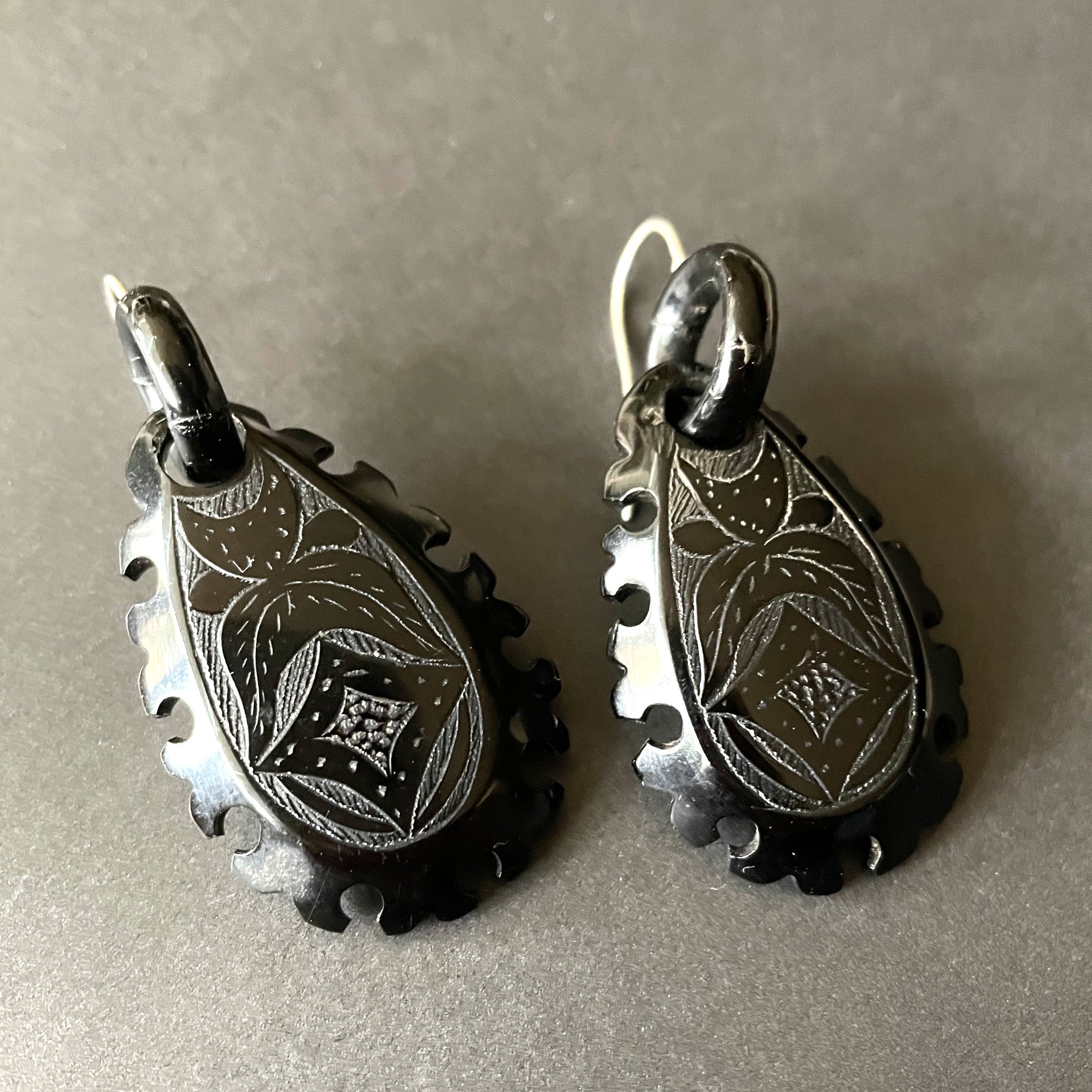 Antique black earrings on a black background.