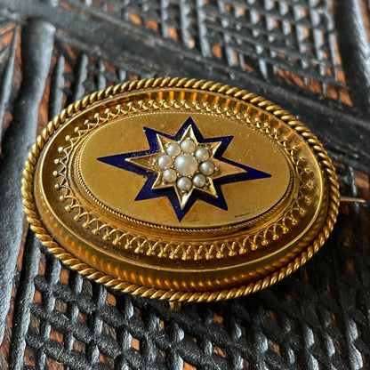 Victorian locket made of gold, pearls and blue enamel with intricate metalwork.